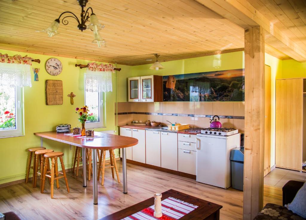 uma cozinha com paredes amarelas e um tecto de madeira em Rogate Anioły em Wetlina