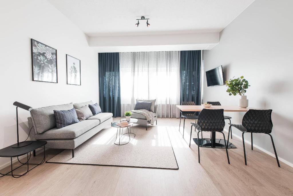 a living room with a couch and a table at Forenom Aparthotel Helsinki Pikku Huopalahti in Helsinki