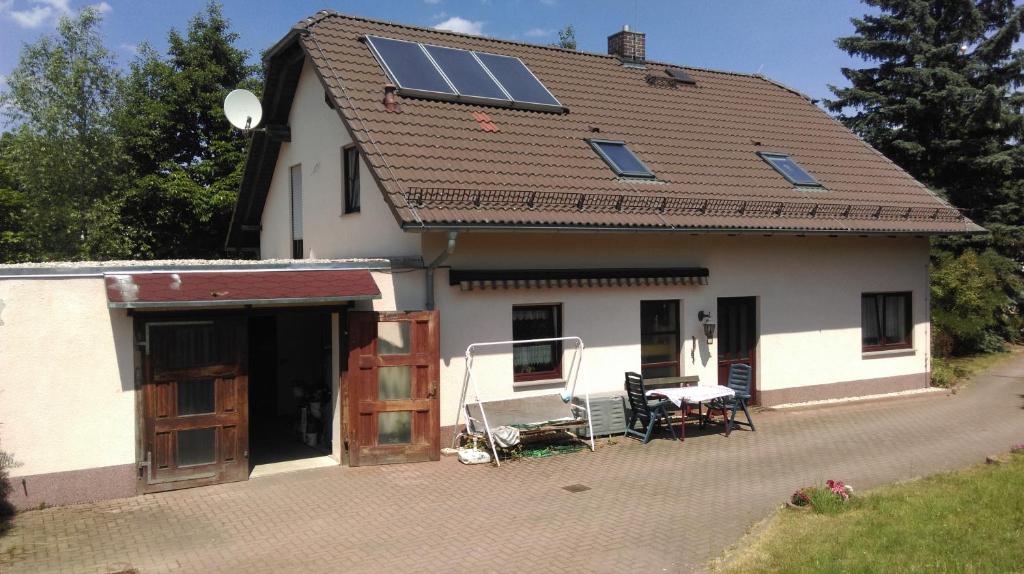 uma casa branca com painéis solares no telhado em Haus am See em Unterwellenborn