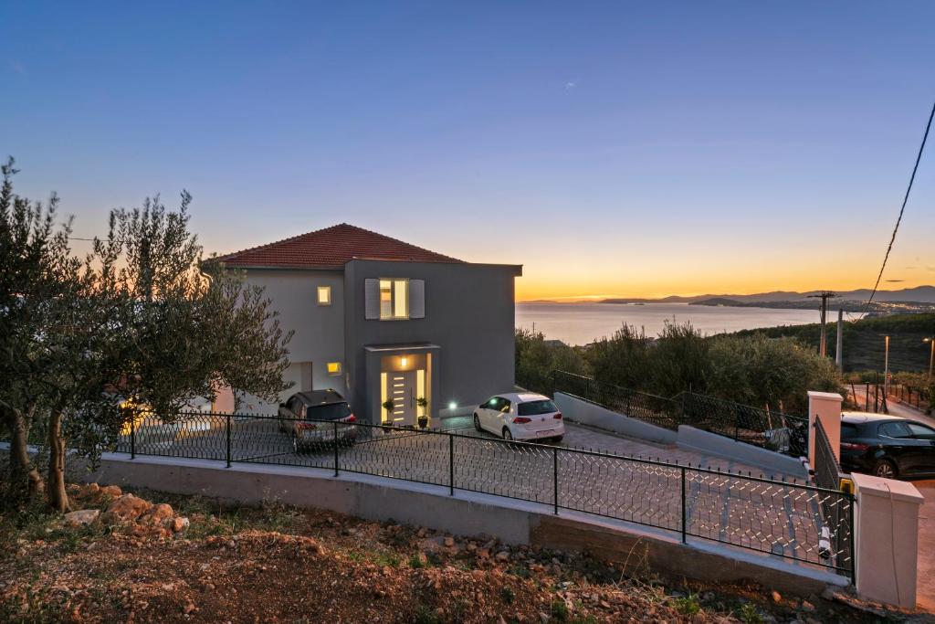 a house with two cars parked in a driveway at A brand NEW VILLA - Infinity in Podstrana