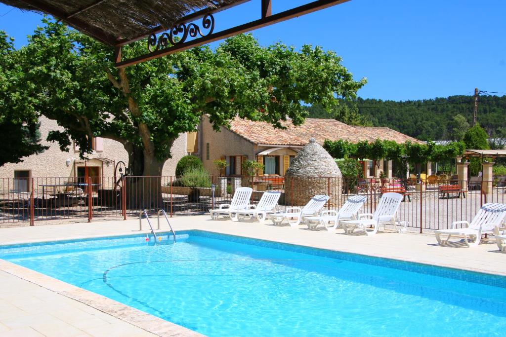 a swimming pool with lounge chairs and a hotel at Chambres & Tables d'hôtes Moulin de Lavon in Gargas