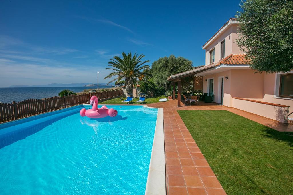 una piscina con un juguete inflable rosa en Villa del mar, en Quartu SantʼElena