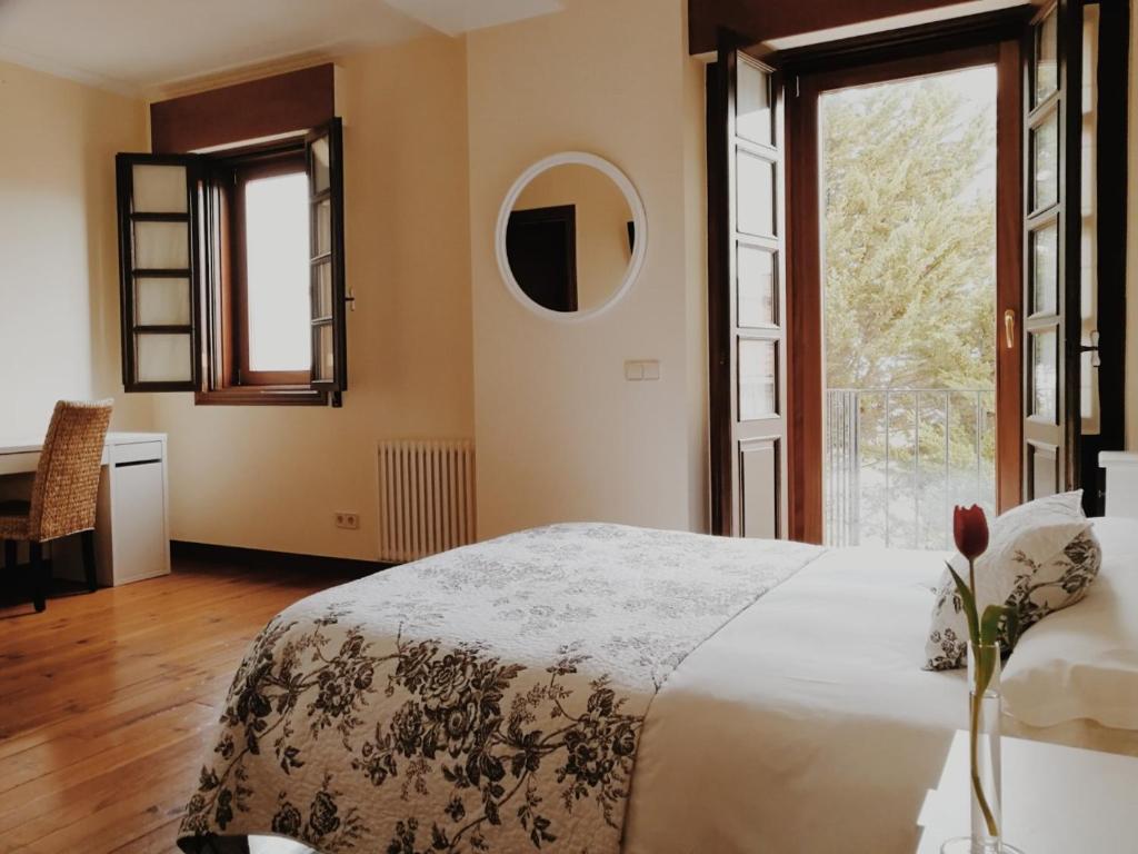 a bedroom with a bed and a large window at Casa do Marqués in Baiona