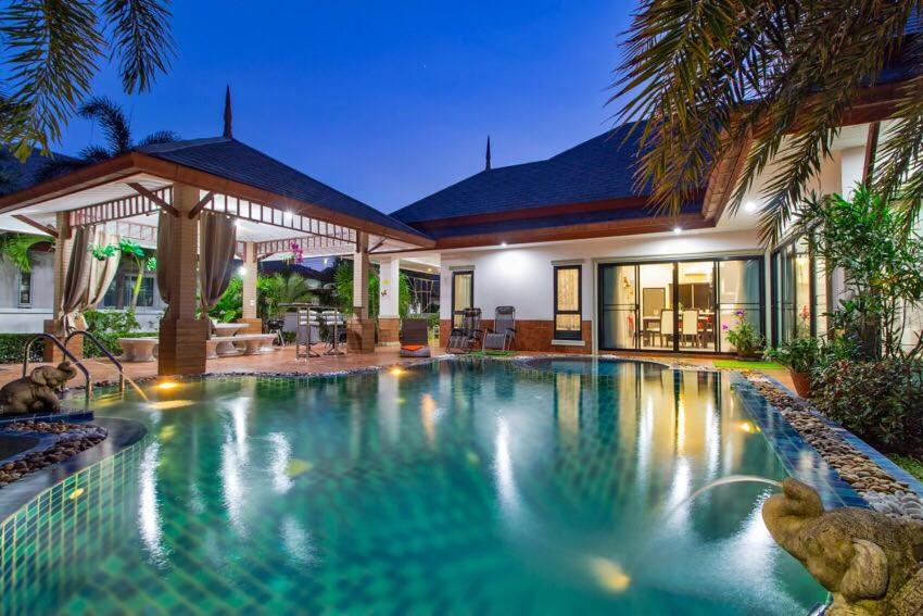 a swimming pool in front of a house at Villa Nataly in Na Jomtien