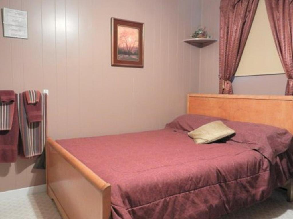 - une chambre avec un lit doté d'un couvre-lit rouge dans l'établissement Domaine Joseph Ross Bed and Breakfast, à Cap-Chat