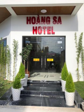 HOÀNG SA HOTEL في كام رنه: فندق فيه نباتات خزف امام الباب
