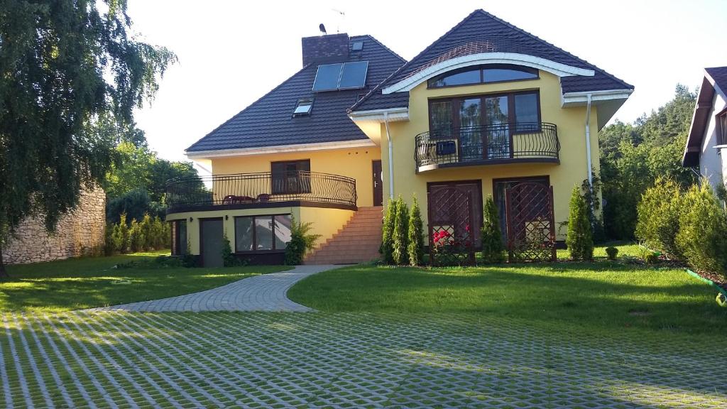 una grande casa gialla con un vialetto di mattoni di Villa Jura Pokoje Gościnne a Żarki