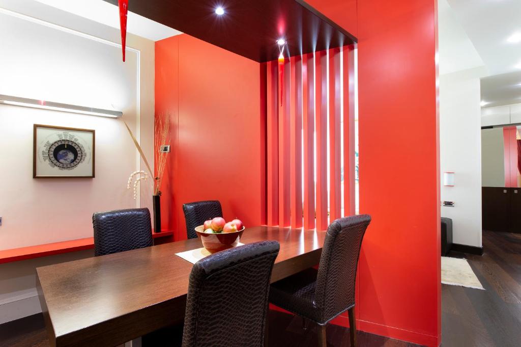 a dining room with red walls and a wooden table and chairs at Art Hotel Orologio in Bologna