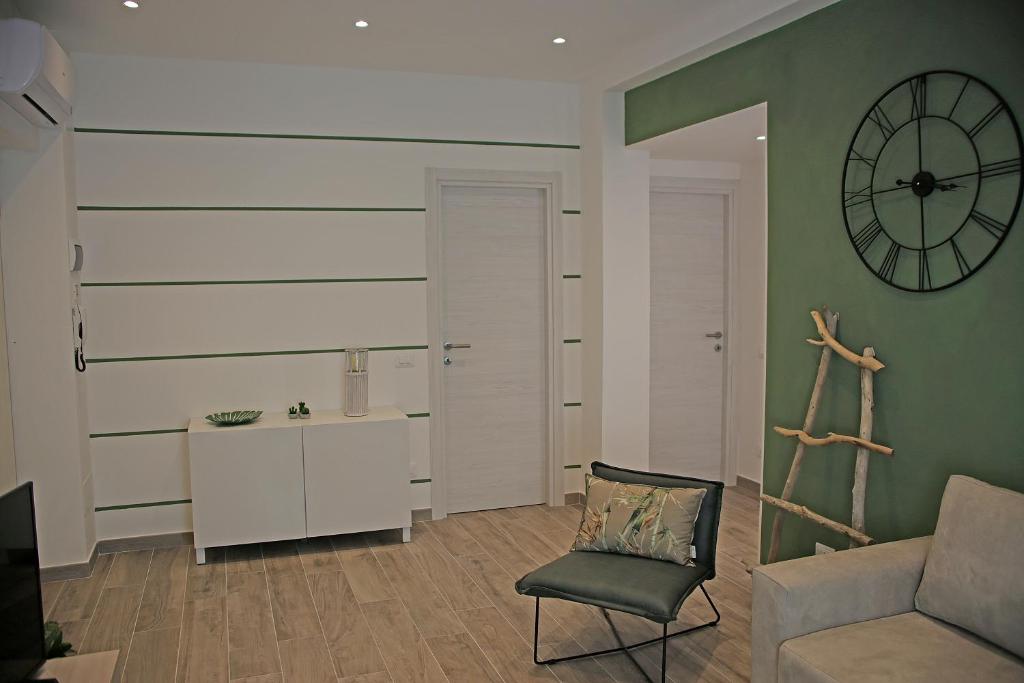 een woonkamer met een stoel en een klok aan de muur bij Da Sabbi in La Spezia