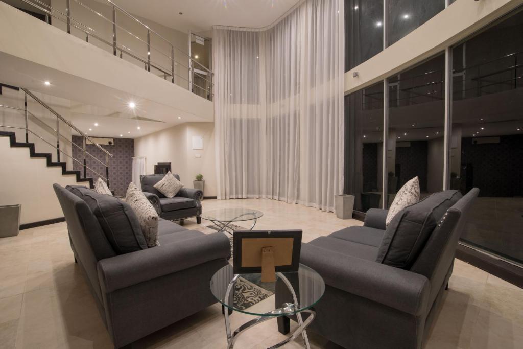 a living room with two couches and a glass table at W Residence Kandy in Kandy