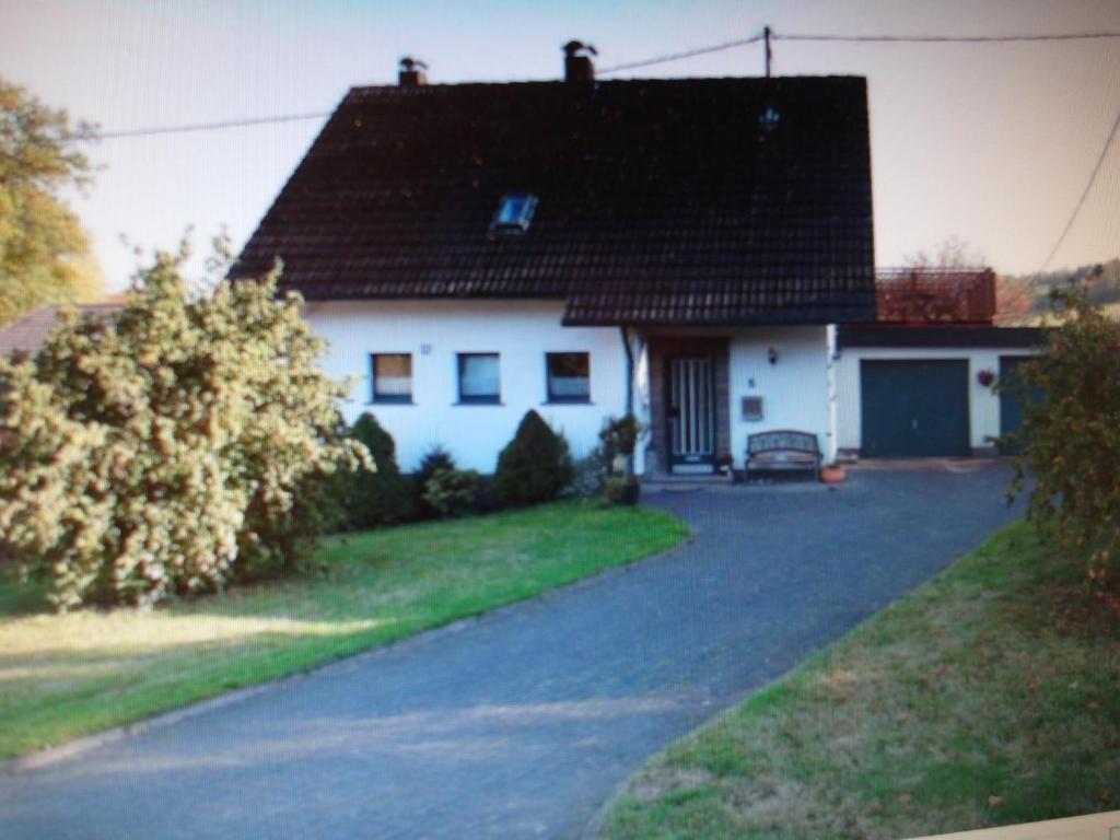 uma casa branca com um telhado preto e uma entrada em FEWO1 1OG Scheldt em Nümbrecht