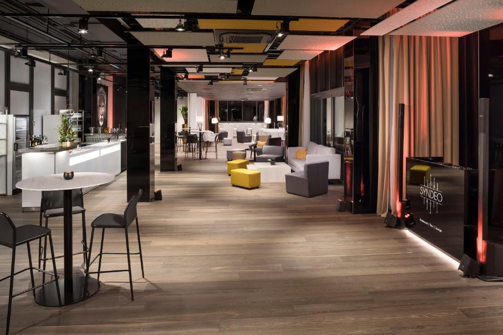 a lobby with tables and chairs in a building at INNSiDE by Meliá Leipzig in Leipzig