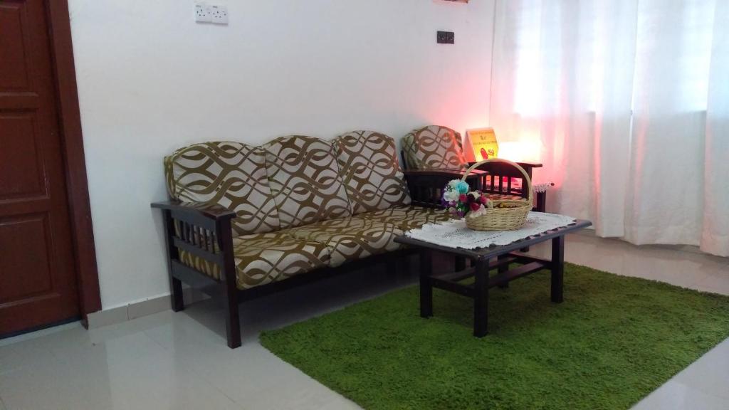 a living room with a couch and a table at Homestay Rgee in Kuantan