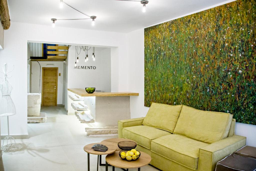 a living room with a yellow couch and a painting at MEMENTO B&B Piran in Piran