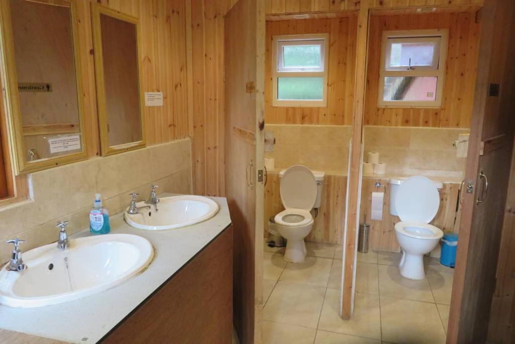 a bathroom with two sinks and a toilet at Pine Marten Bar Glenmore Pods in Aviemore
