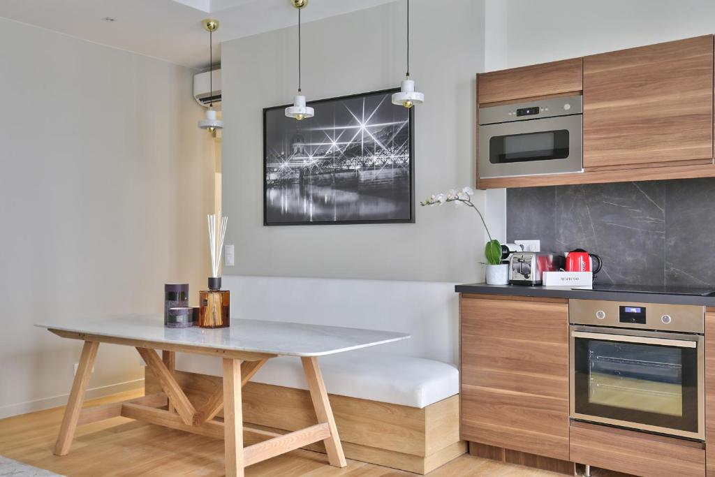 - une cuisine avec une table en bois, une table et un four micro-ondes dans l'établissement 70 - Authentic Parisian Flat, à Paris