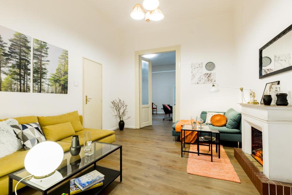 ブダペストにあるUnique Riverside Apartmentのリビングルーム(黄色のソファ、暖炉付)