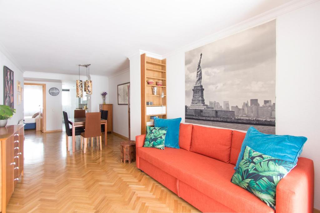 馬德里的住宿－Homelike Plaza Mayor，一间带红色沙发的客厅和一间用餐室