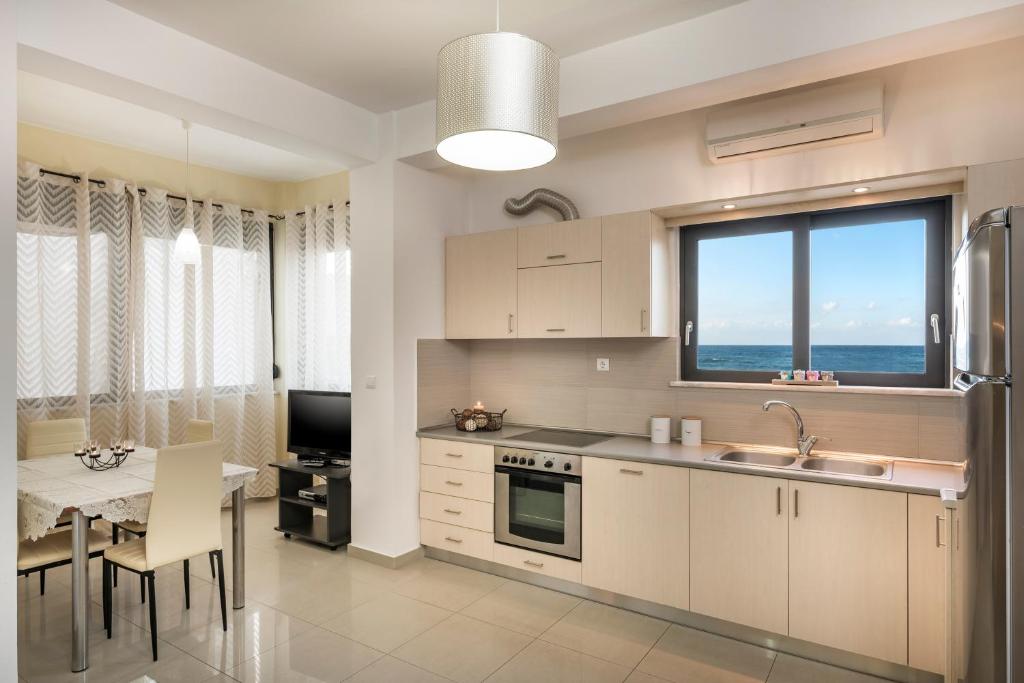 uma cozinha com um lavatório e uma mesa com uma sala de jantar em Athina's Flat on the sea em Agia Marina Nea Kydonias