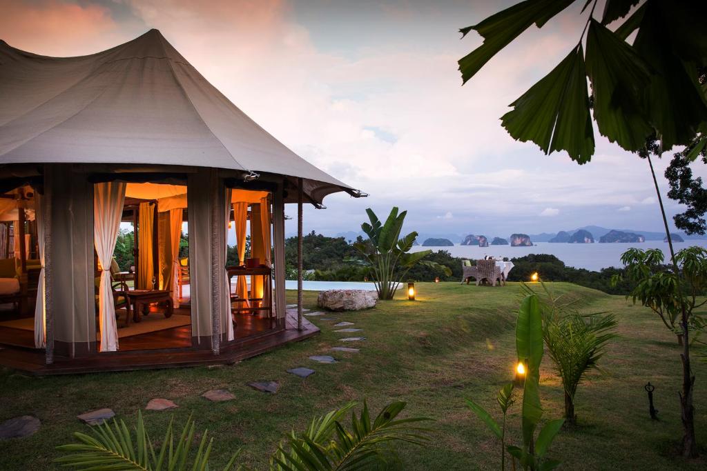 a luxury tent with a view of the water at dusk at 9 Hornbills Tented Camp in Ko Yao Noi