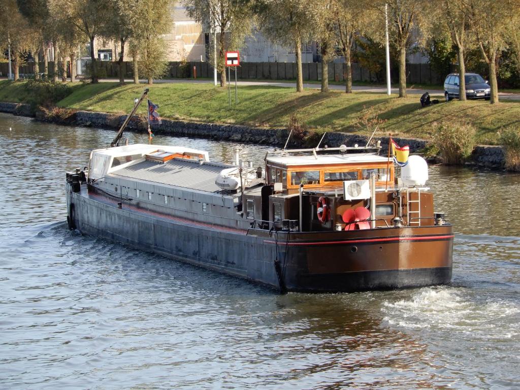 a boat in the water on a river at BlackPearl Boat&Breakfast in Terneuzen