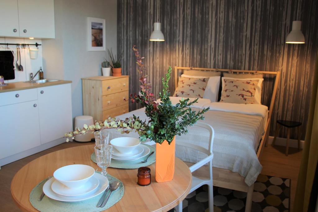 Un dormitorio con una cama y una mesa con platos. en Apartament Studio 208 en Biała Podlaska
