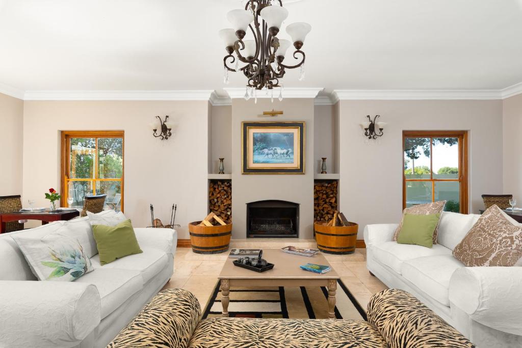 sala de estar con 2 sofás blancos y chimenea en Thomson's Accommodation, en Ciudad del Cabo