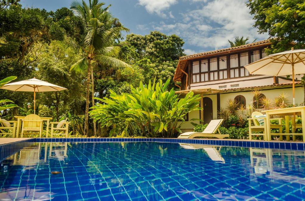 a swimming pool in front of a house at Pousada Villa Bahia in Trancoso