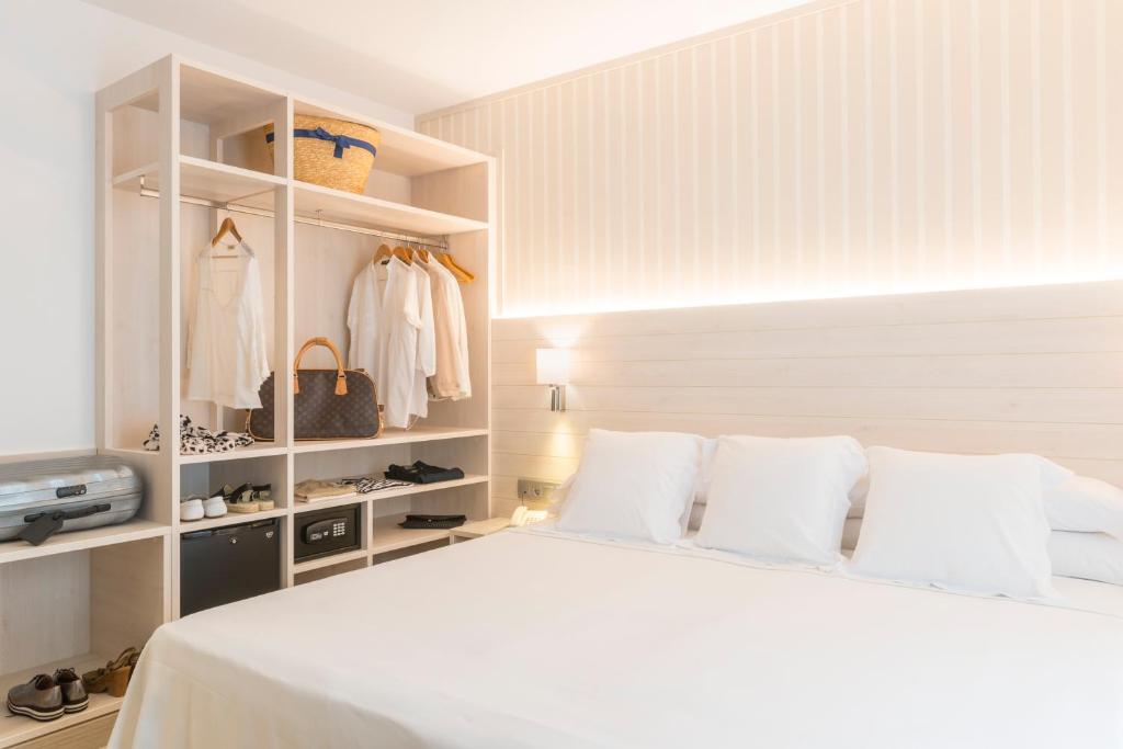 a bedroom with a white bed with white pillows at Hotel Marsol in Lloret de Mar