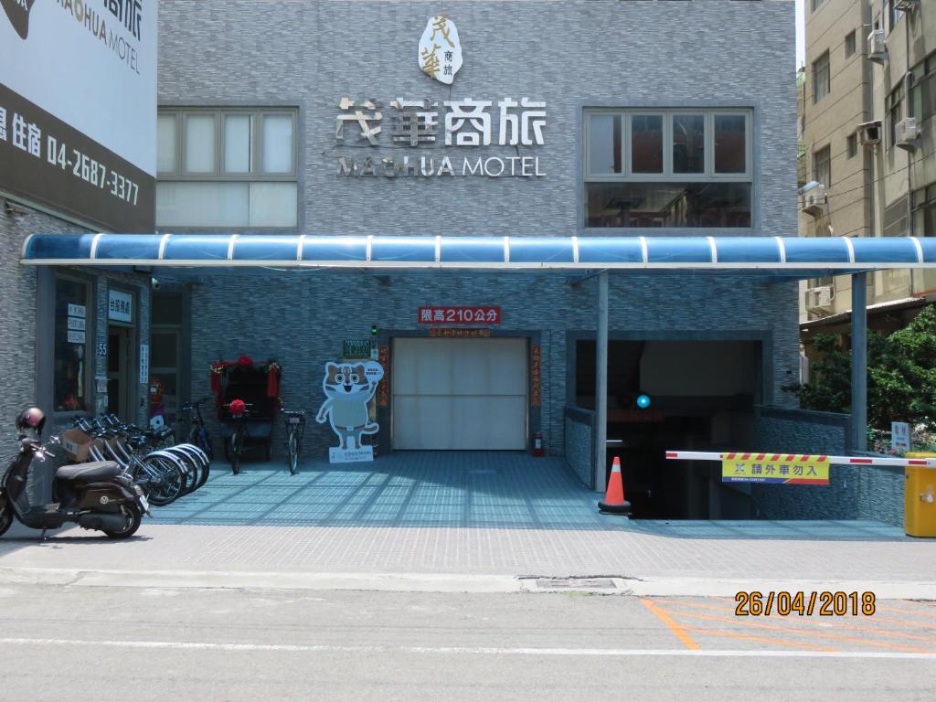 a building with a parking lot with a garage at Mao Hua Motel in Dajia