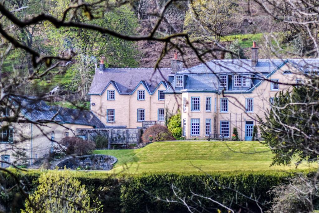 una grande casa su una collina con un cortile verde di The Old House, Llwyn Madoc a Llanwrtyd Wells