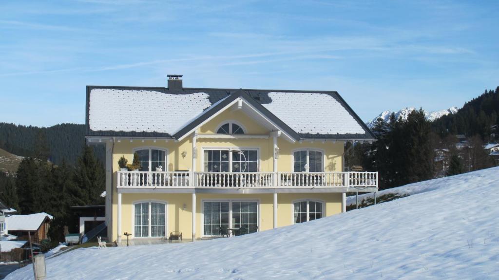 リーツラーンにあるAlpentraumの雪山の上の黄色い家