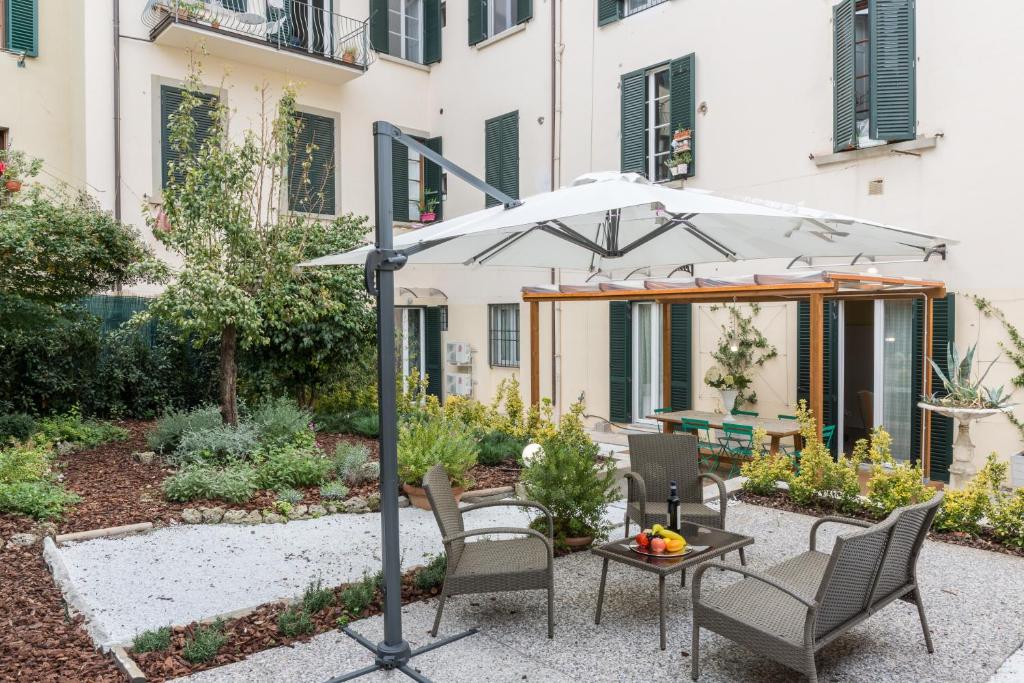 patio con tavolo, sedie e ombrellone di Pilastri Majestic Garden a Firenze