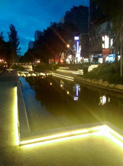 a city street at night with a body of water at Haogong Hotel in Taichung