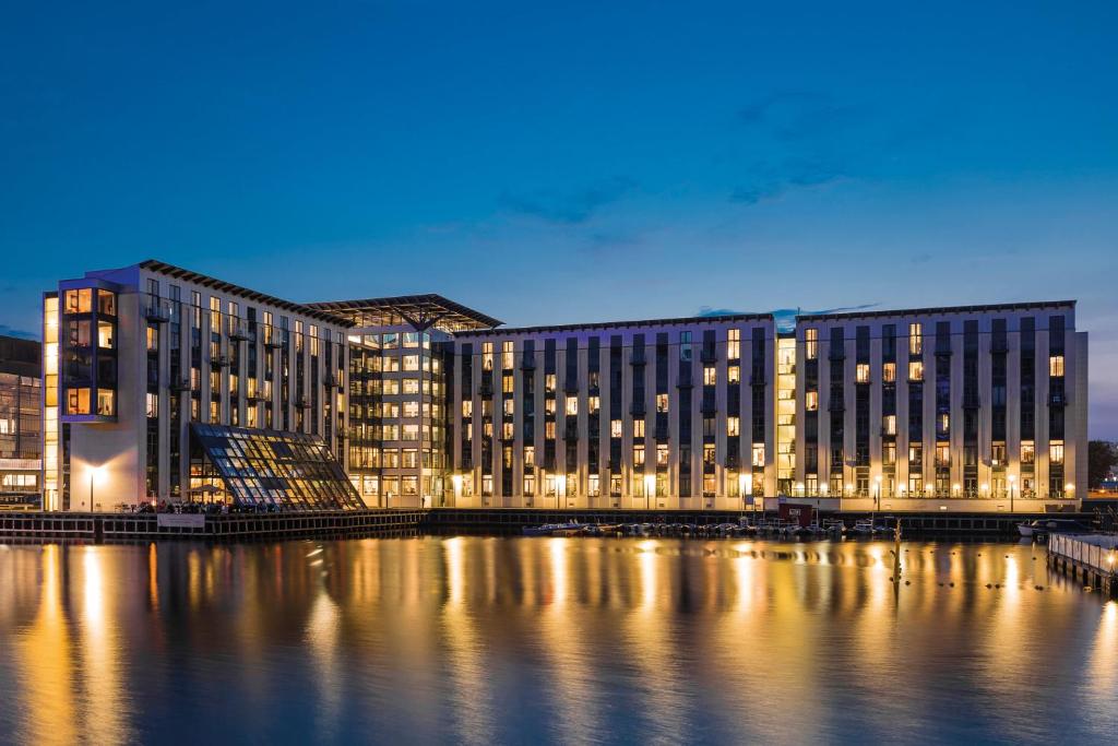 a large building on the water at night at Copenhagen Island Hotel in Copenhagen