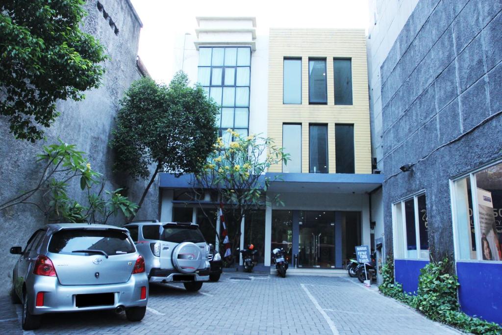 un estacionamiento con autos estacionados frente a un edificio en N Hotel Harmoni Jakarta, en Yakarta