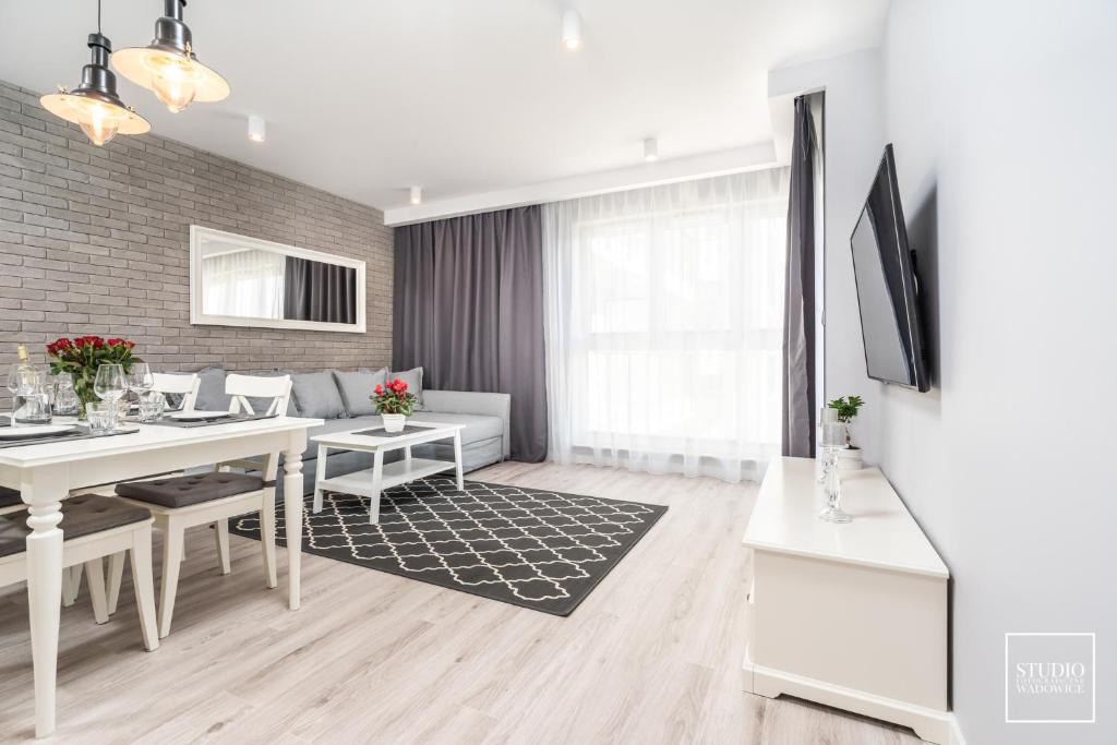 sala de estar con mesa blanca y comedor en Exclusive Vermelo Apartment en Cracovia