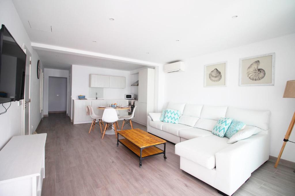 Una sala de estar con un sofá blanco y una mesa. en Apartaments Es Port ETVPL14335-13394, en Colonia de Sant Jordi