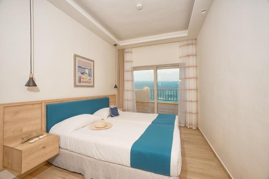 Ένα ή περισσότερα κρεβάτια σε δωμάτιο στο Cavos Bay Hotel & Studios 