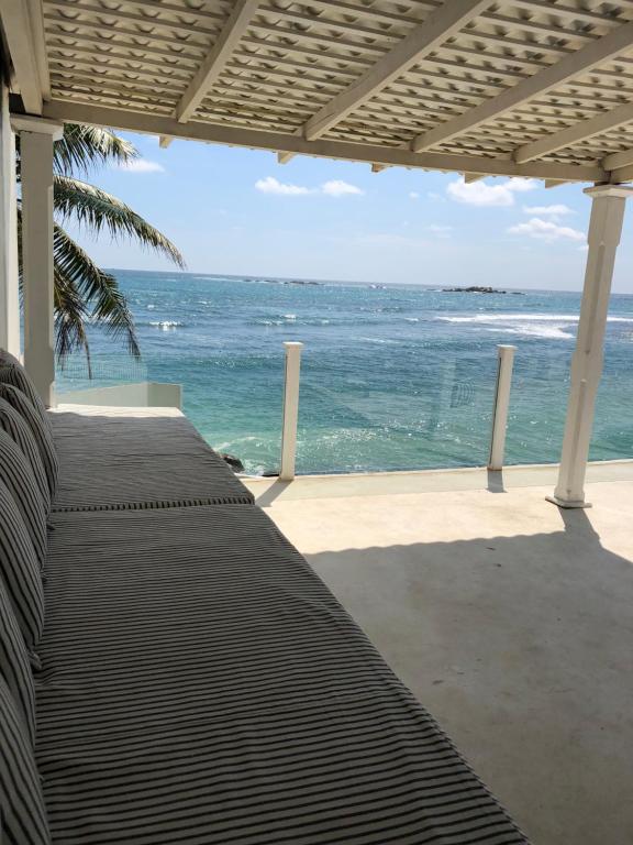 a view of the ocean from the porch of a beach house at Galle Henna Beach House in Unawatuna