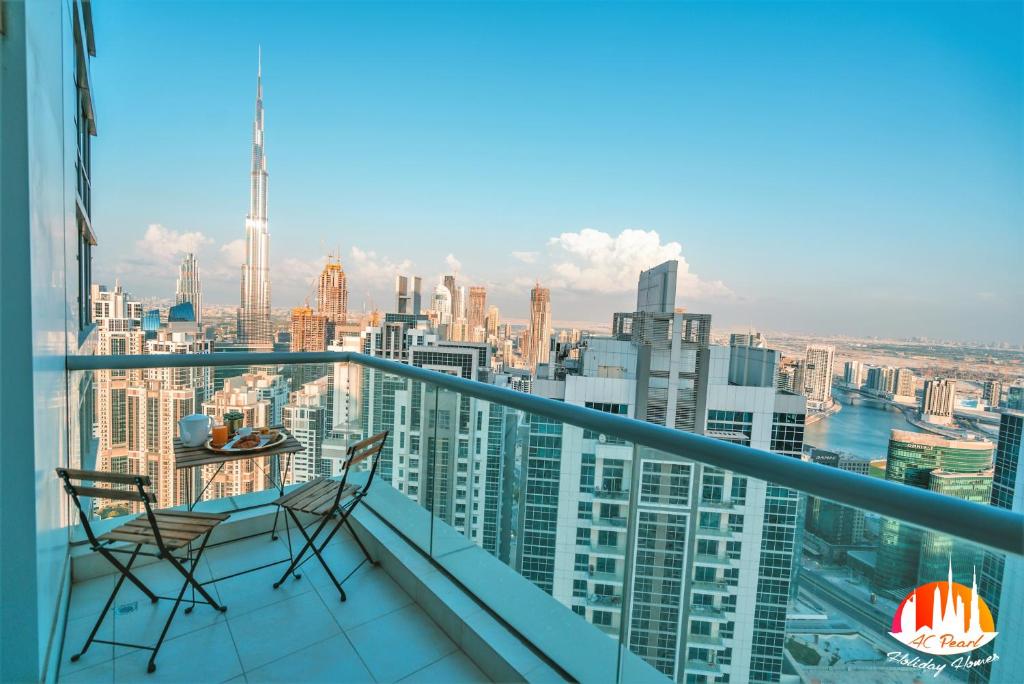 a balcony with two chairs and a view of the city at A C Pearl Holiday Homes - The Loft with Burj Khalifa View in Dubai