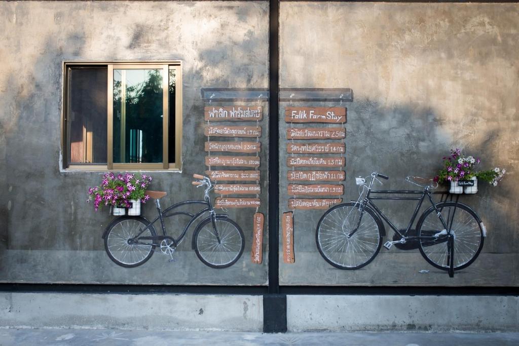 dos bicicletas estacionadas en un lado de un edificio en Falik Farm Stay en Phra Nakhon Si Ayutthaya