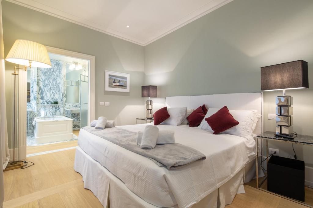 a bedroom with a large white bed with red pillows at Villoresi Mansion in Florence