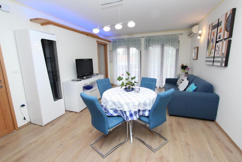 sala de estar con mesa y sillas azules en Apartments Daria, en Rovinj