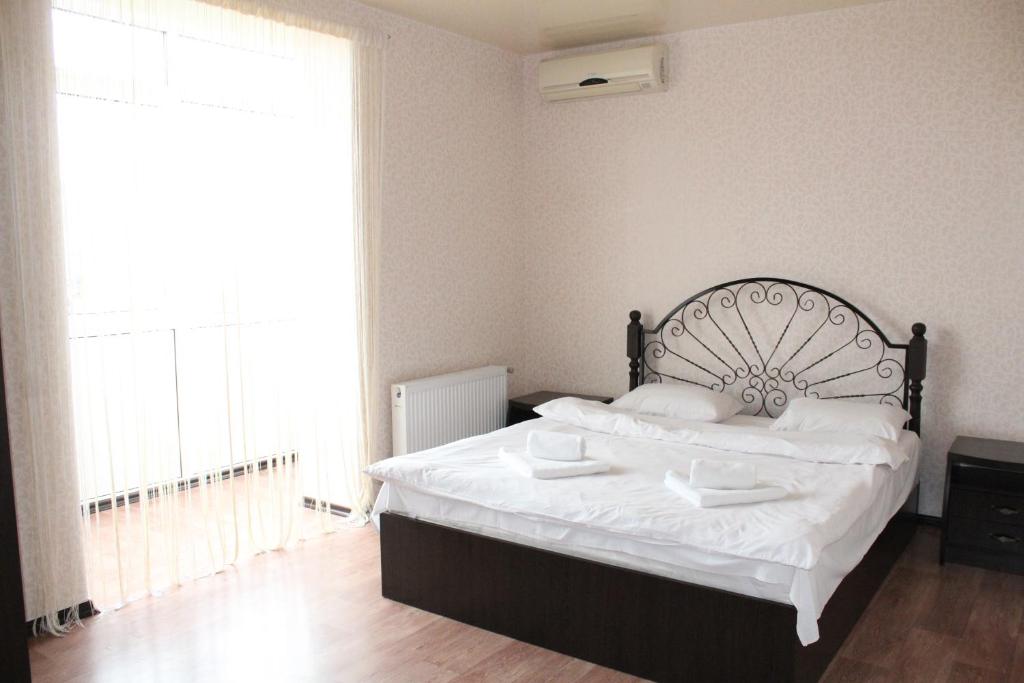 a bedroom with a large bed with a large window at Апартаменти Рилєєва, 25 in Kyiv