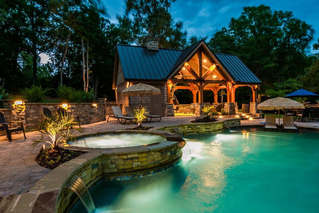a home with a swimming pool and a house at The Estate in Eatonton 