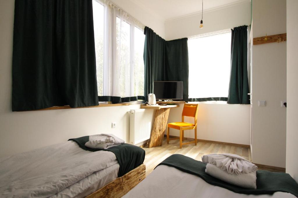a bedroom with two beds and a desk and window at Insomnia in Akhaltsikhe