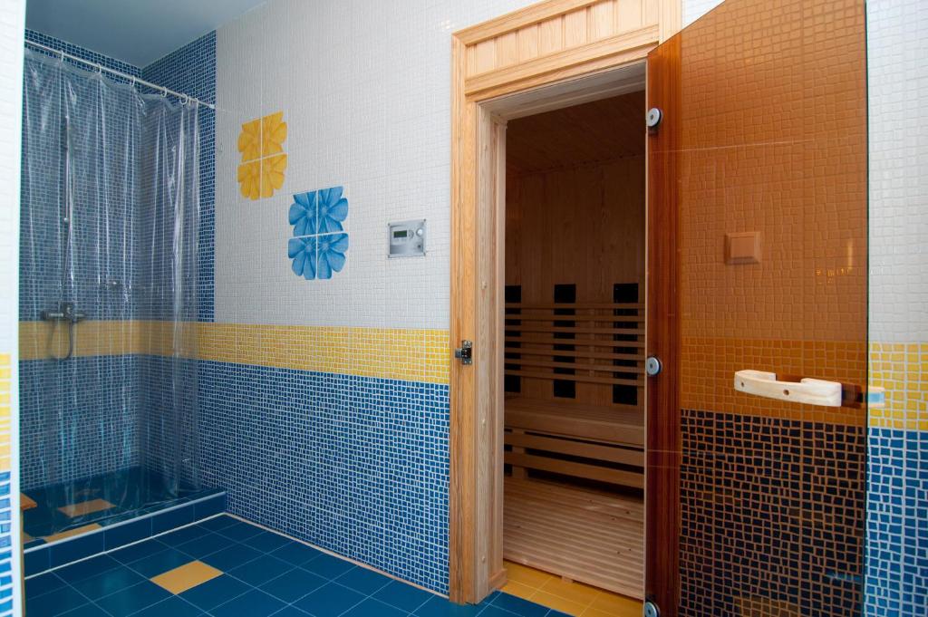 baño con azulejos azules y amarillos y ducha en Regata Palace Hotel, en Sunny Beach