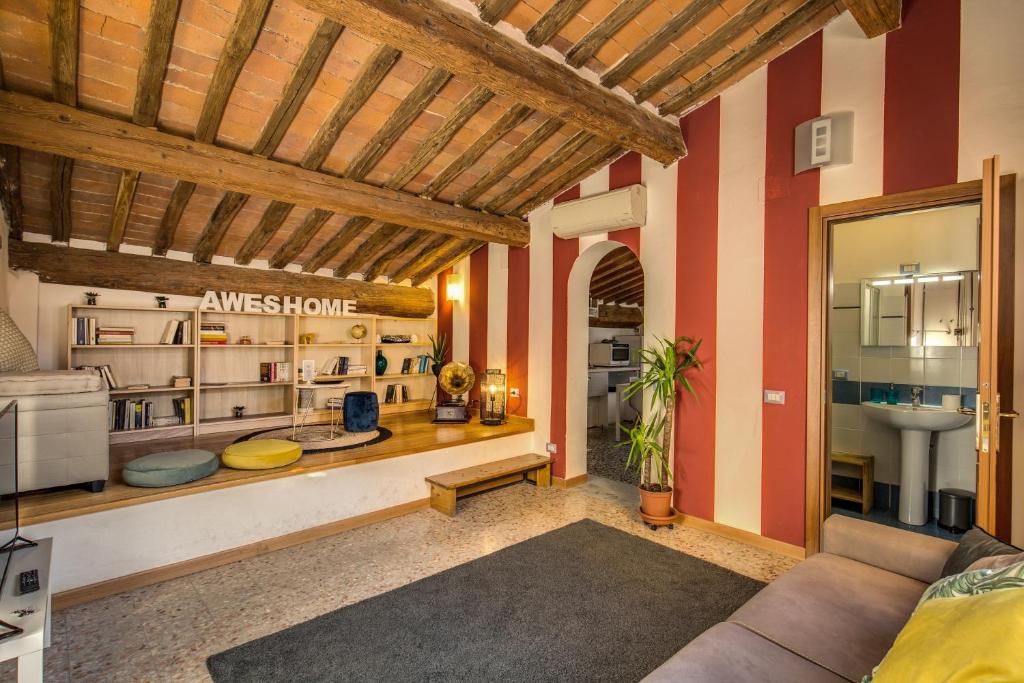 una sala de estar con paredes rojas y blancas. en AwesHomeItaly - Lungarno Bellavista Penthouse, en Pisa