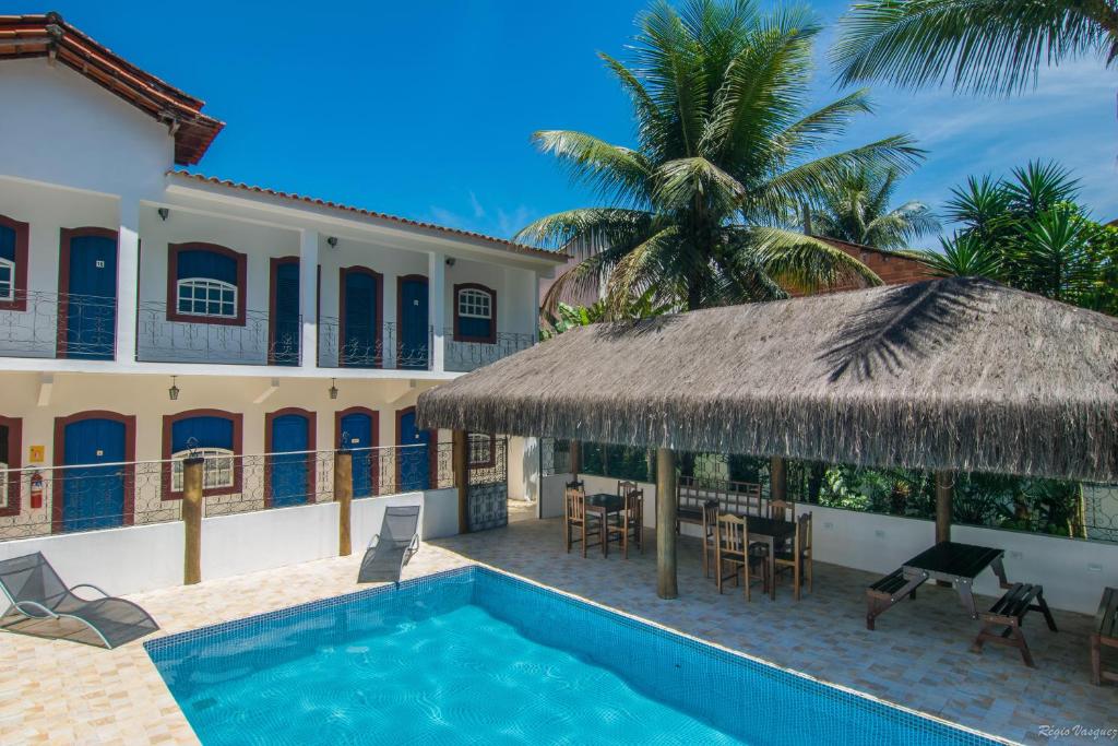 eine Villa mit einem Pool und einer Palme in der Unterkunft Pousada Lua Clara in Paraty